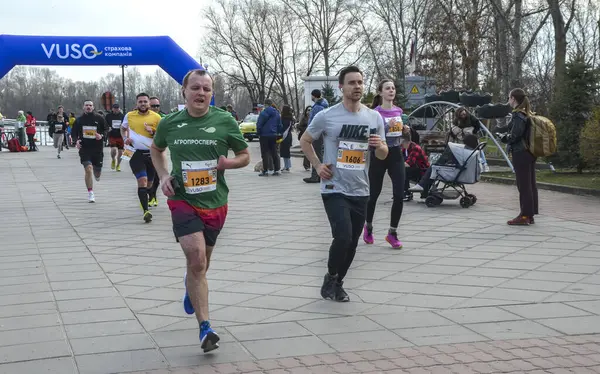 Asfalt yolda koşan katılımcıların katılacağı açık hava maratonu yarışını izleyenler izleyecek. Sahne, bahar aylarında enerjik atmosferi gösteriyor.