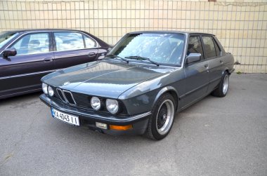 Gri 1987 BMW 5 Serisi, sağlam yapı kalitesi, sağlam motorları ve dengeli arkadan çekişli kullanımıyla bilinen çok sevilen bir klasiktir.