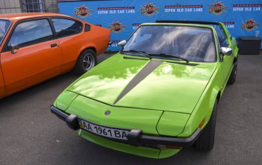Canlı yeşil klasik Fiat X19 iki koltuklu orta motor üstü spor araba keskin, kama şekilli tasarımı, farları patlaması ve çıkarılabilir Targa top
