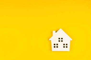 Minyatür beyaz oyuncak evi sarı renkli modern moda arka planında izole edilmiş. Ev kredisi sigortası hayali ev konsepti. Boşluğu kopyala