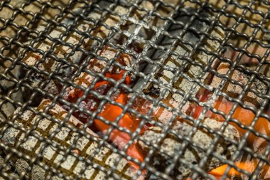 Çiğ et mangalı ya da yakiniku, yemek ve restoran konseptine hazır yanan kömür ızgarasının seçici odak noktası.