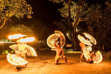 Bangkok, Tayland - 15 Ekim 2022: Kimliği belirsiz oyuncular Tayland 'da Koh Samet' te bir restoranda alacakaranlıkta ateş salınımı yaptılar.