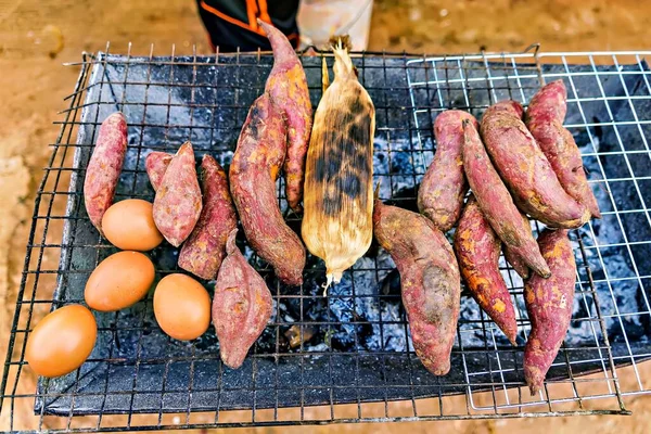 Sweet potato and egg grilled on stove in countryside store.Thailand.