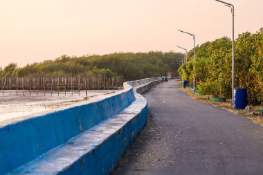 Samut Prakan, Thailand - January, 14, 2023 : People on the road along the beach at sunset at Samut Prakan, Thailand.