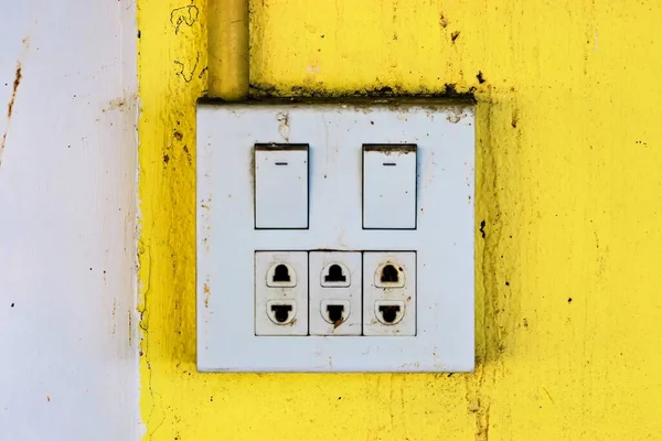 Electric power outlet socket ground and switch on wall.