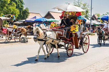 Lampang, Tayland - 19 Aralık 2022: Tatil gezisindeki insanlar Lampang, Tayland 'daki Phrathat Lampang Luang tapınağındaki at arabaları.