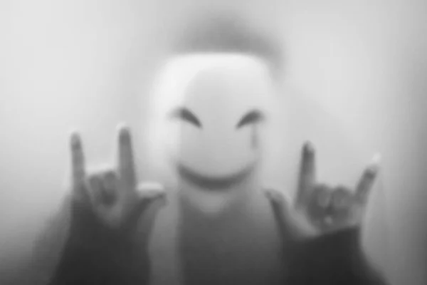 バンコク 2023 笑顔のマスクの神秘的な男は 曇ったガラスの後ろに立っています 不気味なスタイル ぼやけたイメージ ハロウィーンコンセプト — ストック写真
