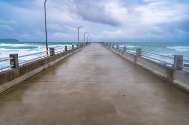 Mavi gökyüzü ile deniz boyunca beton iskele