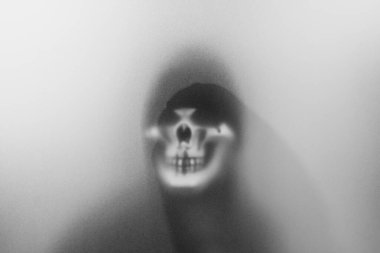 Bangkok, Tayland - 20 Ağustos 2023: Donmuş camların arkasındaki korku maskesinin gölgesi. Gizemli adam. Görüntü efekt ve tahıl ekle..