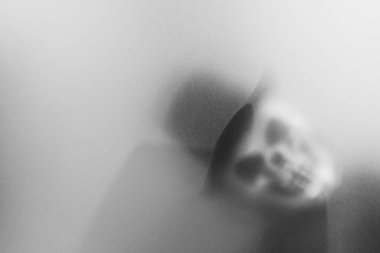 Bangkok, Tayland - 20 Ağustos 2023: Donmuş camların arkasındaki korku maskesinin gölgesi. Gizemli adam. Görüntü efekt ve tahıl ekle..