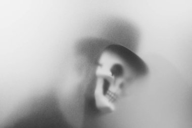 Bangkok, Tayland - 20 Ağustos 2023: Donmuş camların arkasındaki korku maskesinin gölgesi. Gizemli adam. Görüntü efekt ve tahıl ekle..