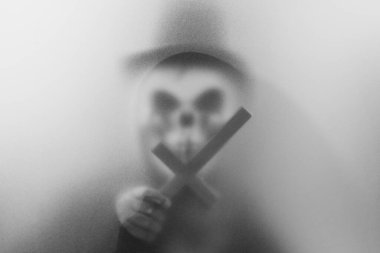 Bangkok, Tayland - 20 Ağustos 2023: Donmuş camların arkasındaki korku maskesinin gölgesi. Gizemli adam. Görüntü efekt ve tahıl ekle..