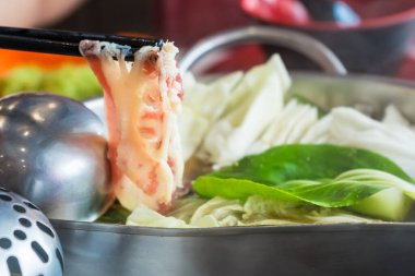 Shabu et sosu sıcak çorbanın içinde ince dilimlenmiş et ve sebzeler suda kaynatılmış..