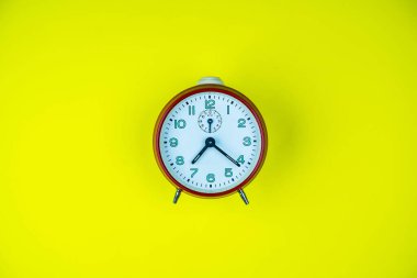 Sarı arka planda izole edilmiş saat. Yaklaş..