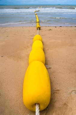 Sahildeki sarı şamandıra manzarası.
