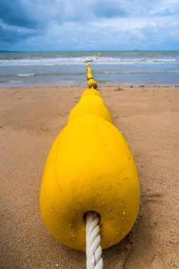 Sahildeki sarı şamandıra manzarası.