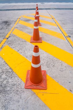 Parlak turuncu trafik konileri ve sarı çizgiler, park etmeyin..