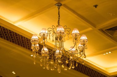 Büyük bir odada yüksek bir tavandan sarkan avize