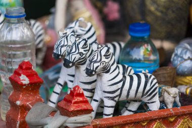 Geleneksel el yapımı zebra heykelcikleri. Kırmızı süslemeler ve plastik şişelerle düzenlenmiş.