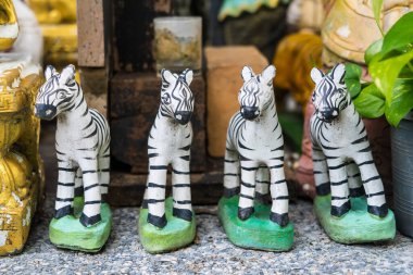 Geleneksel el yapımı zebra heykelcikleri. Kırmızı süslemeler ve plastik şişelerle düzenlenmiş.