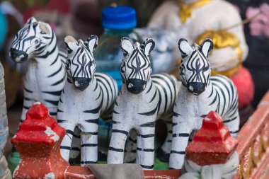 Geleneksel el yapımı zebra heykelcikleri. Kırmızı süslemeler ve plastik şişelerle düzenlenmiş.