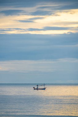 A fishing boat floats on calm waters in the early morning, creating a serene and peaceful scene. clipart