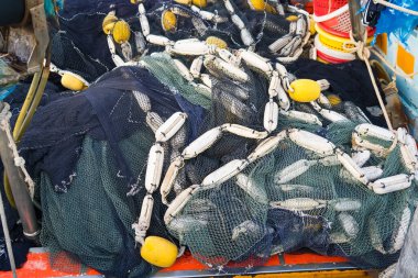 A close-up shot of tangled fishing nets with yellow and white buoys on a traditional Thai fishing boat. clipart