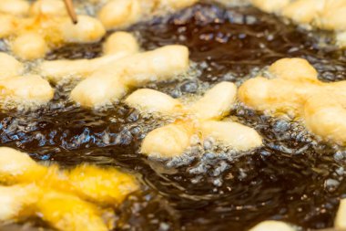 Yakın plan altın sarısı Tayland hamur çubukları kızgın yağda kızarıyor..