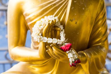 Bu yakın plan görüntü, altın bir Buda heykelinin, huzur ve sükuneti sembolize eden meditasyon jesti ile karışık detaylarını yakalar..