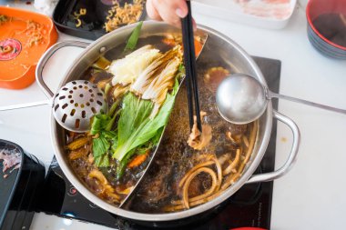 Sıcak tencere yemek dünyasına dalın, kaynayan bir tencere lezzetli çorba ile bir dizi taze sebze, deniz ürünü ve et, paylaşmak için mükemmel.