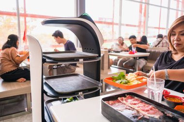 Samut Prakan, Tayland - 12 Haziran 2024: Tayland 'da bir Tayland Lokantasında Robot Yemek Servisi, Samut Prakan' da Teknolojinin Bütünleşmesini Gösteriyor.