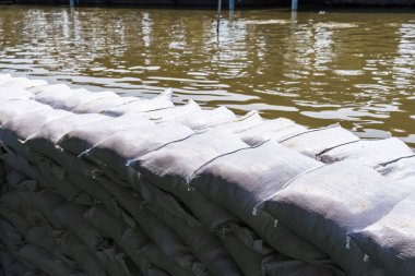 Kum torbaları potansiyel selleri önlemek için nehir tarafından düzgünce hizalanır ve yakındaki bölgeler için koruyucu bir önlem görevi görür.