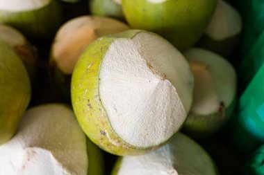 Fresh green coconuts with tops cut off, ready for enjoying fresh coconut water.