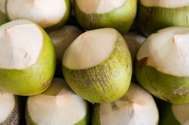 Fresh green coconuts with tops cut off, ready for enjoying fresh coconut water. clipart