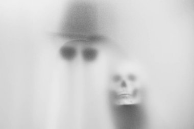 Spooky Ghost in Sunglasses and Skull Amidst Mist  Haunting Art for Halloween and Mysterious Themes at Bangkok, Thailand. clipart