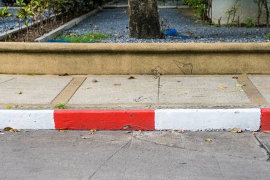 Kırmızı ve beyaz kaldırımları olan hareketli bir şehir caddesi park yeri olmadığını, şehir hayatının özünü yakaladığını gösteriyor..