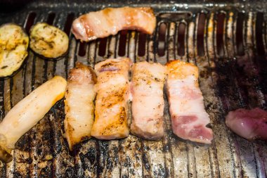 Kömürle pişirilmiş ızgara domuz eti ile Kore barbeküsünün otantik tadını tecrübe edin. Yemek deneyiminizi yeni bir seviyeye çıkaracak dumanlı bir lezzet sunuyor..