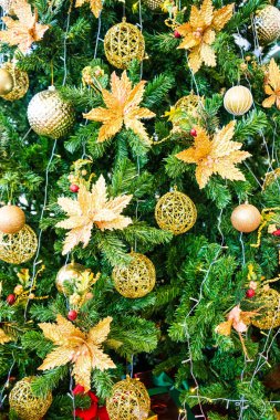 Parlak süsler, süsler ve sıcak ışıklarla süslenmiş altın bir Noel ağacı büyülü ve zarif bir tatil atmosferi yaratıyor..