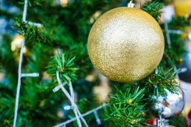 Parlak süsler, süsler ve sıcak ışıklarla süslenmiş altın bir Noel ağacı büyülü ve zarif bir tatil atmosferi yaratıyor..