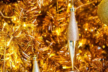 Parlak süsler, süsler ve sıcak ışıklarla süslenmiş altın bir Noel ağacı büyülü ve zarif bir tatil atmosferi yaratıyor..