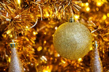 Parlak süsler, süsler ve sıcak ışıklarla süslenmiş altın bir Noel ağacı büyülü ve zarif bir tatil atmosferi yaratıyor..