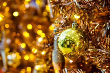 Parlak süsler, süsler ve sıcak ışıklarla süslenmiş altın bir Noel ağacı büyülü ve zarif bir tatil atmosferi yaratıyor..