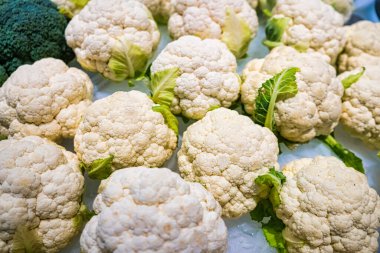 Taze toplanmış organik karnabahar başları buzda sergilenir. Sağlıklı yemek pişirmek için birebirdir..