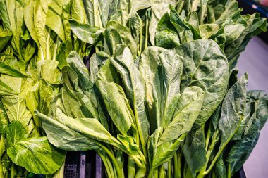 Diverse Selection of Green Leafy Vegetables for Healthy Cooking Displayed in Market Baskets clipart