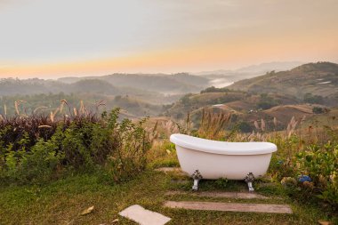 Serene Outdoor Bathtub with Scenic Mountain View at Sunrise: Experience Ultimate Relaxation Surrounded by Nature's Beauty in a Tranquil Setting clipart