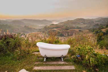 Serene Outdoor Bathtub with Scenic Mountain View at Sunrise: Experience Ultimate Relaxation Surrounded by Nature's Beauty in a Tranquil Setting clipart