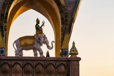 Phetchabun, Tayland - Ocak, 06, 2025: Tayland Tapınağındaki Fil ve İlah Heykeli, Bağlılığın Bir Yansıması, Sanatsal Mükemmellik ve Tayland 'ın Phetchabun kentindeki Batan Güneşin Parıltısı.