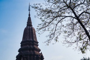 Lop Buri, Tayland - Ocak 02, 2025: Karmaşık oymalar ve dik pagoda yapısı ile kadim taş tapınak Lop Buri, Tayland 'da açık mavi bir gökyüzüne karşı