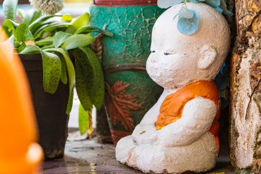 Lop Buri, Tayland - Ocak 02, 2025: Turuncu cüppeli renkli keşiş heykelleri Tayland 'ın Lop Buri kentinde gün ışığında taştan bir yüzeyde sergilenen bağış kaseleri