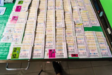 Bangkok, Tayland - 18 Aralık 2024: Bangkok, Tayland 'da birden fazla satırda numaralar ve ayrıntılar gösterilerek yan yana dizilmiş renkli piyango biletleri yığını